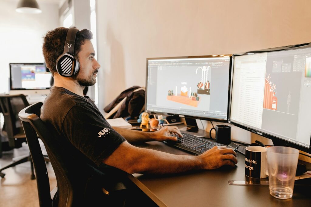 a man wearing headphones and sitting at a desk with a computer